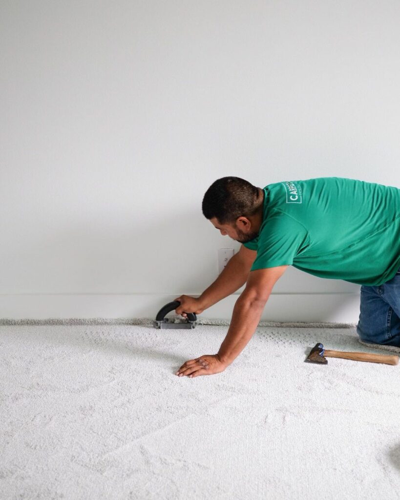 worker installing carpet