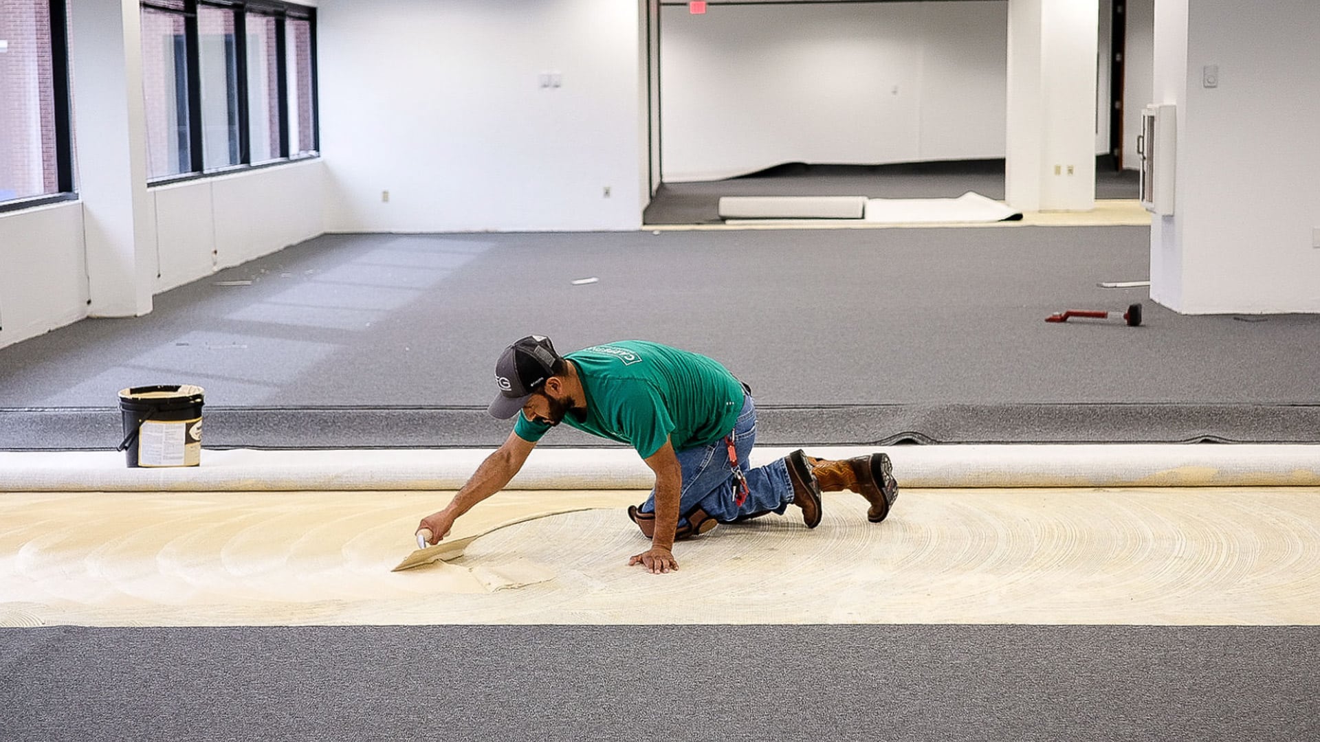 Carpet Now employee applying glue on floor