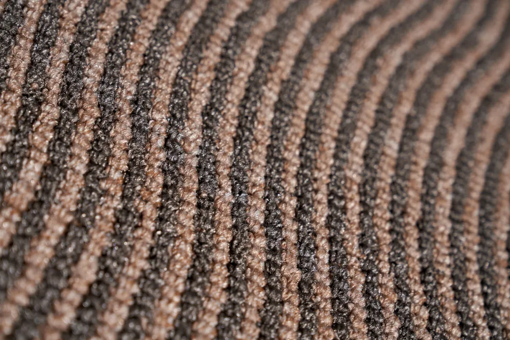 Dark relief carpet texture with wavy, tight rows for unusual background.
