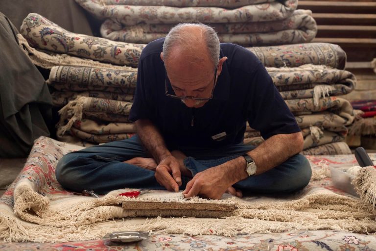Experienced carpet installer working on carpet edges and seams — the kind of craftsmanship that goes into a whole-home carpet installation done right